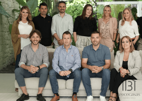 Trececasas la inmobiliaria premium. Foto equipo de la empresa trececasas, sentados todos en un sofá.